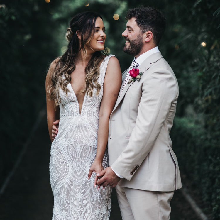 Bride with long styled waves and a soft pinned back section, photographed with her partner