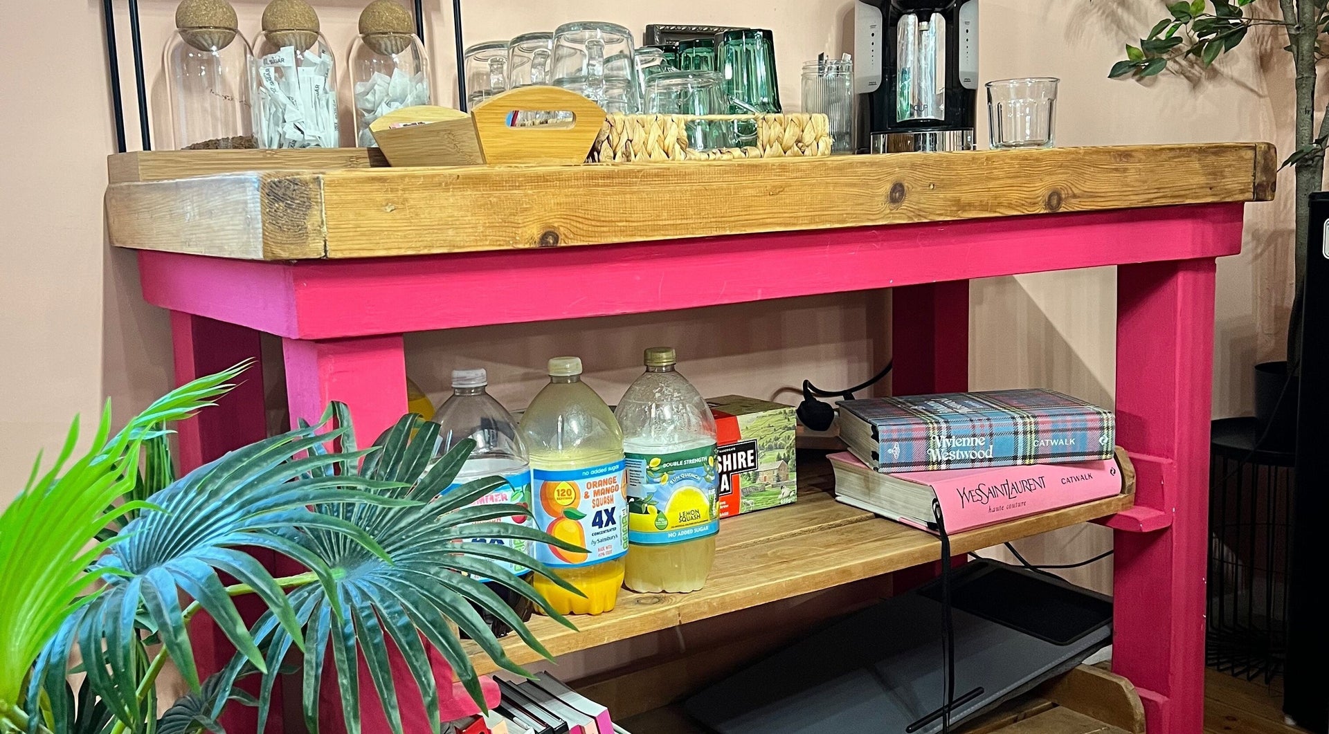 The pink painted drinks console: coffee machine, glasses, squash bottles and fashion books by Vivienne Westwood and Yves Saint Laurent